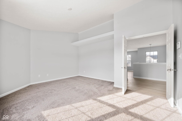 carpeted empty room featuring baseboards