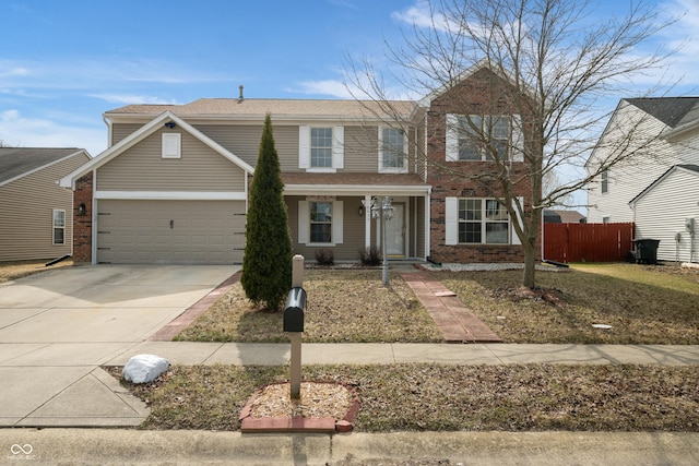 traditional home with driveway, brick siding, an attached garage, and fence