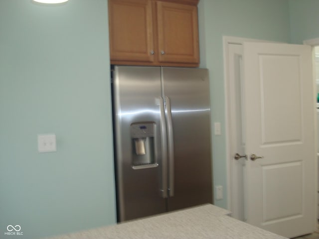 kitchen with stainless steel refrigerator with ice dispenser and light countertops