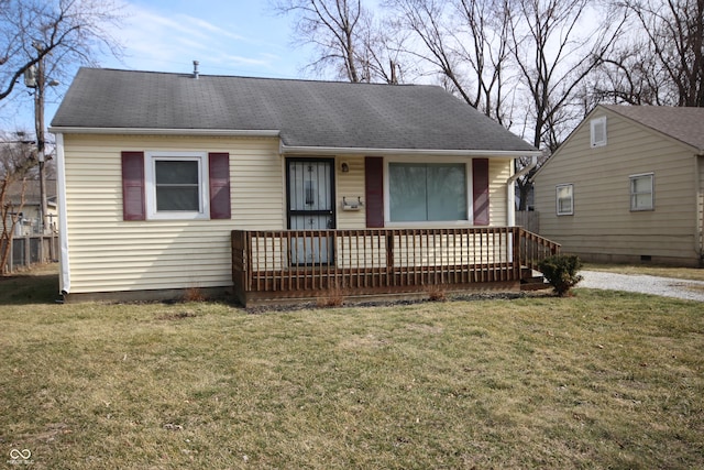 view of front facade featuring a shingled roof and a front yard