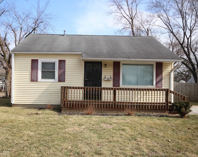 view of front of home featuring covered porch, a shingled roof, and a front lawn