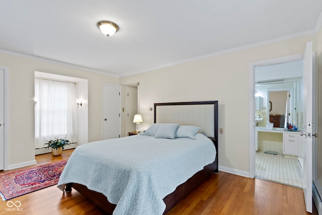 bedroom featuring ensuite bath, crown molding, baseboards, and wood finished floors