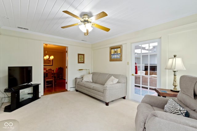 living area with visible vents, carpet floors, crown molding, and ceiling fan with notable chandelier