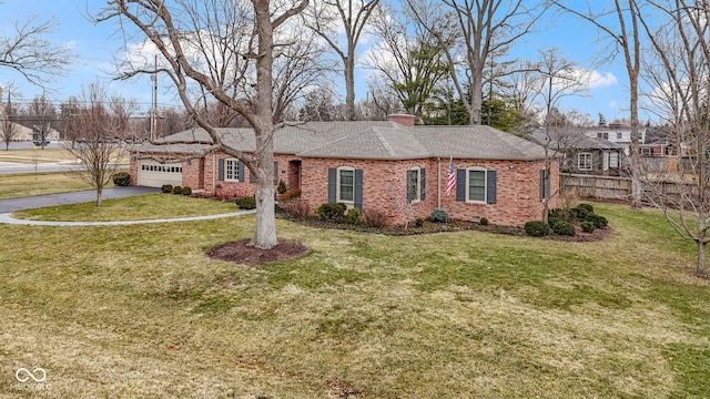 ranch-style house with a front yard, an attached garage, a chimney, aphalt driveway, and brick siding