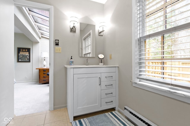 bathroom featuring tile patterned floors, baseboard heating, plenty of natural light, and vanity