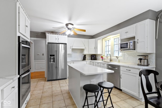 kitchen featuring a sink, stainless steel appliances, tasteful backsplash, and white cabinets