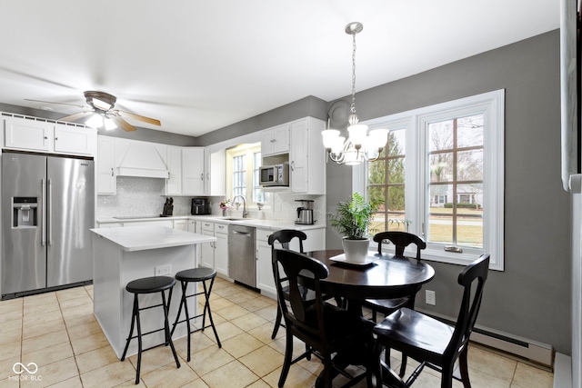 dining space with light tile patterned floors and ceiling fan with notable chandelier