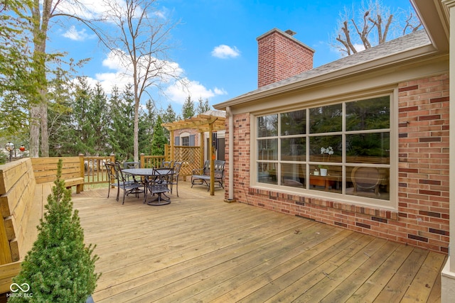 wooden deck with a pergola and outdoor dining area