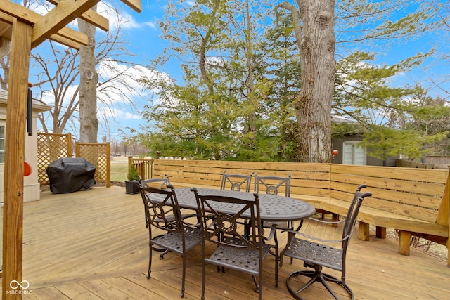 wooden terrace with outdoor dining area and grilling area