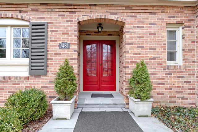 property entrance featuring french doors and brick siding