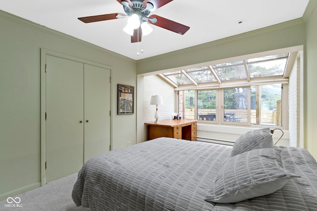 bedroom featuring a baseboard heating unit, crown molding, and a closet