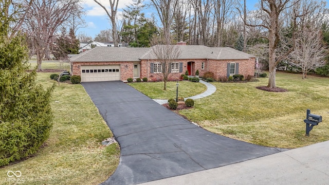 ranch-style home featuring driveway, a front yard, an attached garage, brick siding, and a chimney