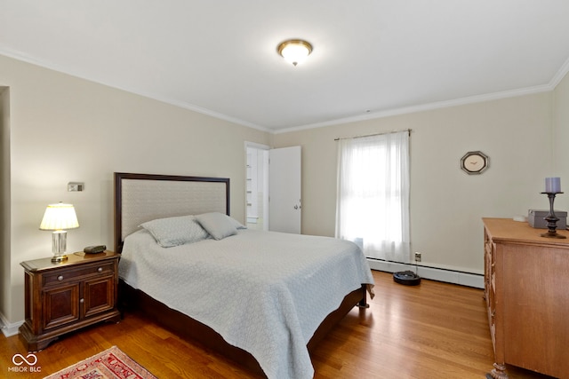 bedroom with ornamental molding, wood finished floors, and a baseboard radiator