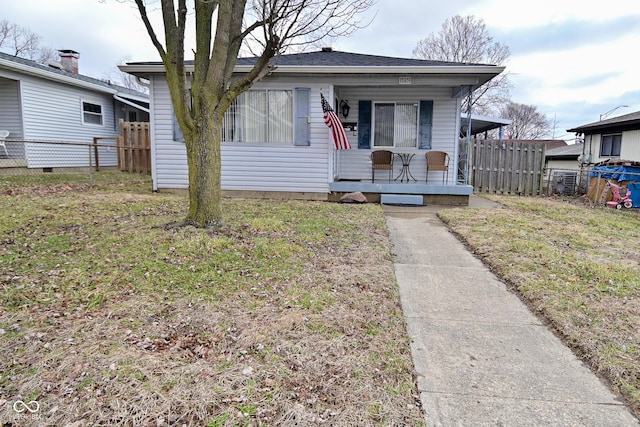 bungalow-style house featuring fence, a front lawn, and a porch