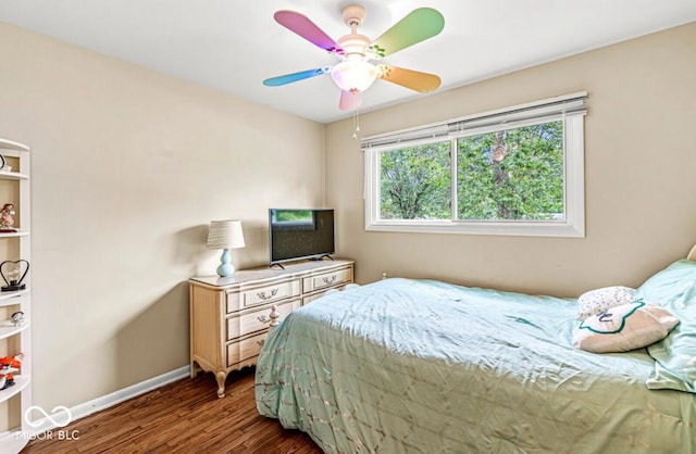 bedroom with dark wood finished floors, ceiling fan, and baseboards