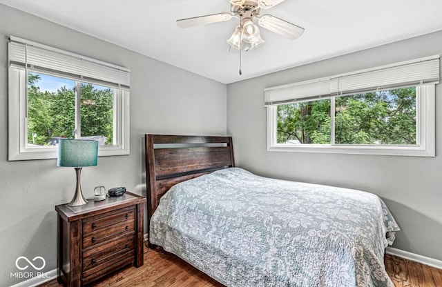 bedroom with ceiling fan, baseboards, and wood finished floors