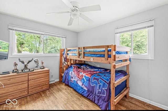 bedroom featuring ceiling fan, baseboards, and wood finished floors