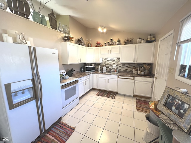 kitchen with a sink, backsplash, white appliances, light tile patterned flooring, and lofted ceiling