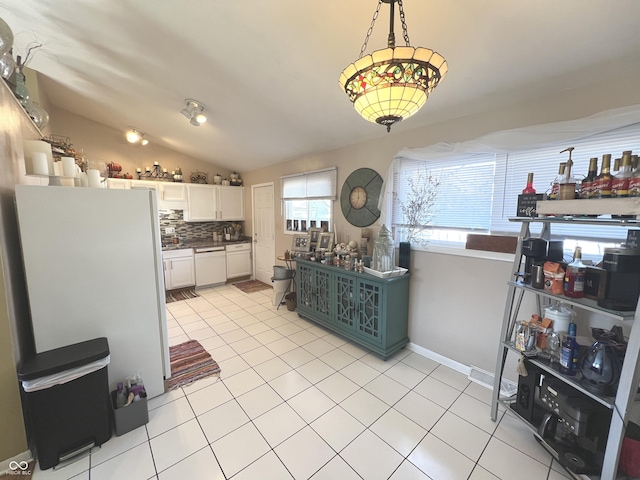 kitchen featuring vaulted ceiling, decorative backsplash, light tile patterned flooring, white cabinets, and white appliances