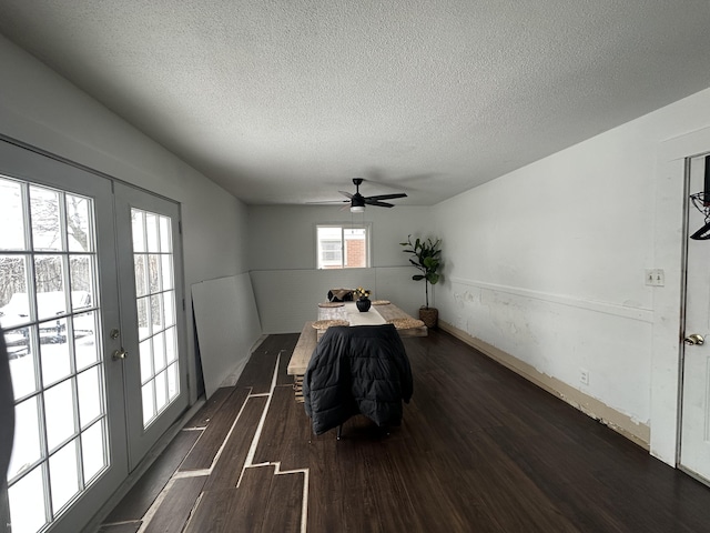 dining space with french doors, dark wood finished floors, and a textured ceiling