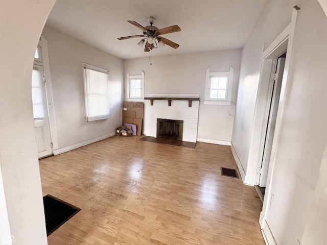 unfurnished living room with a fireplace, visible vents, and light wood-type flooring