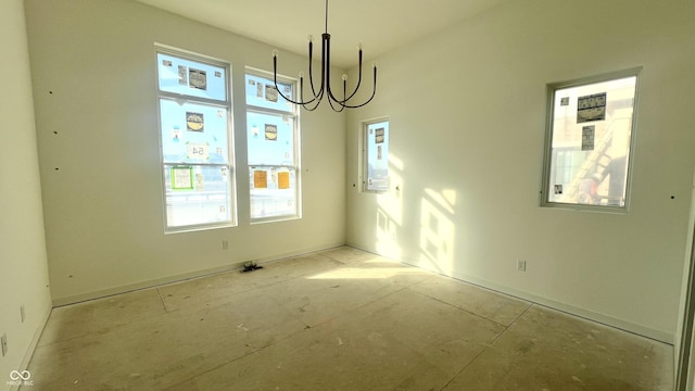 unfurnished room with a wealth of natural light and a notable chandelier