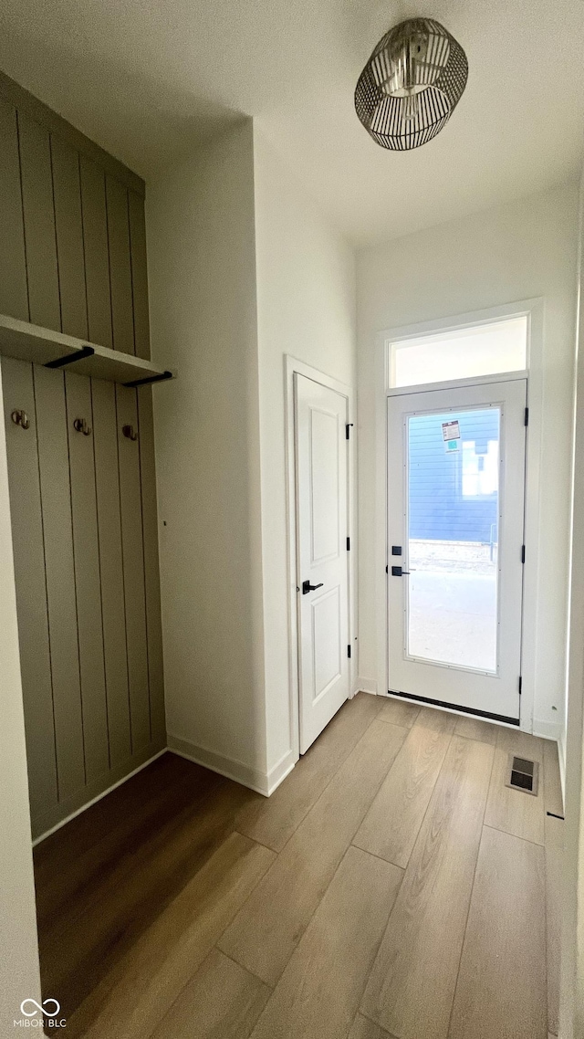 mudroom with wood finished floors, visible vents, and baseboards