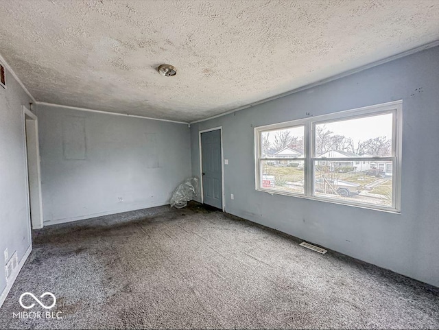 unfurnished room with a textured ceiling, visible vents, and carpet