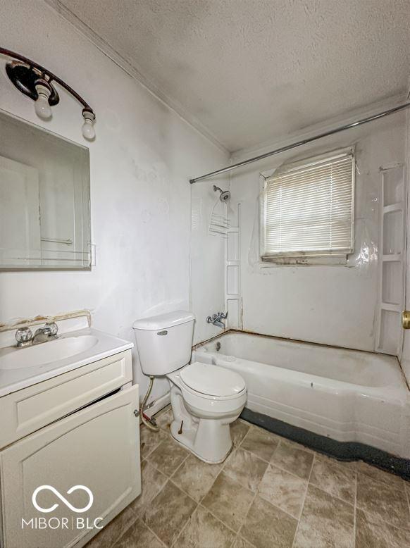full bathroom featuring toilet, a textured ceiling, vanity, and washtub / shower combination