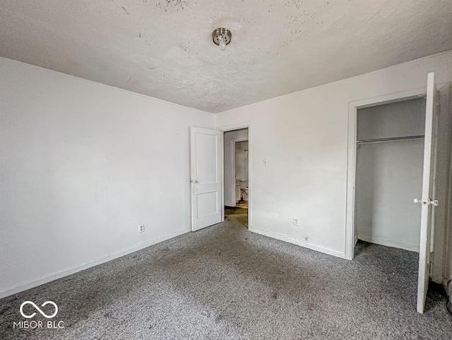 unfurnished bedroom featuring a textured ceiling, a closet, baseboards, and carpet