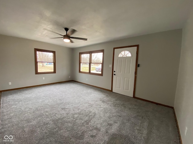 foyer entrance with carpet flooring, baseboards, and a ceiling fan