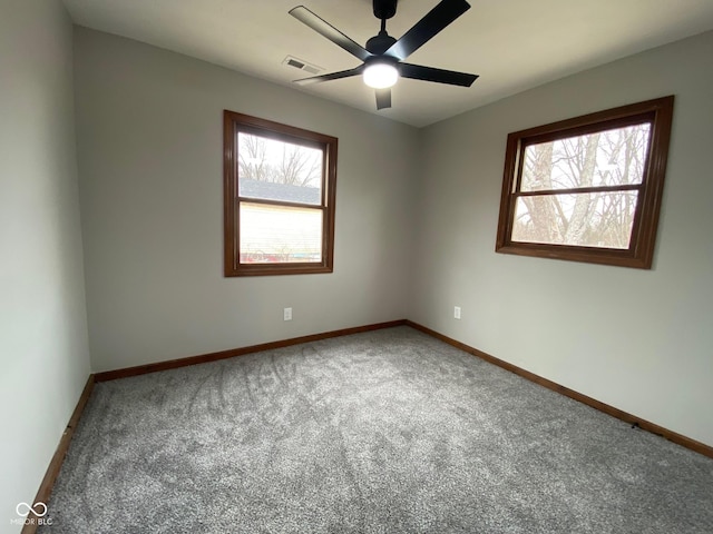 carpeted empty room with baseboards, a healthy amount of sunlight, visible vents, and ceiling fan