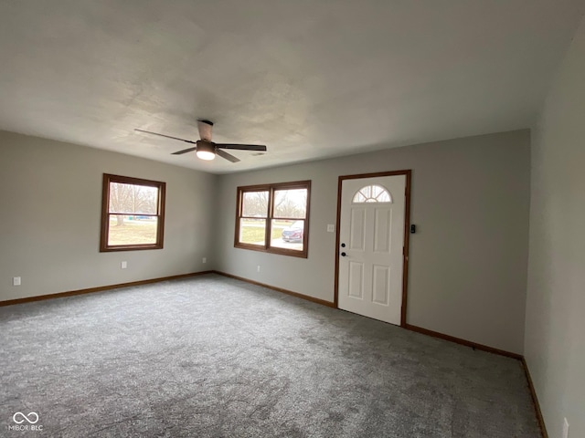 foyer with baseboards, ceiling fan, and carpet flooring