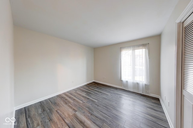 spare room with visible vents, baseboards, and wood finished floors