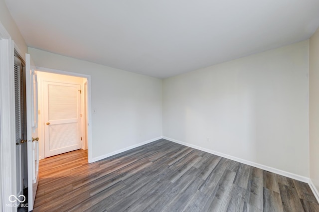 spare room with dark wood finished floors and baseboards