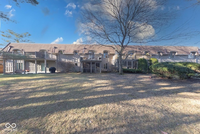 back of property featuring a tiled roof and a lawn