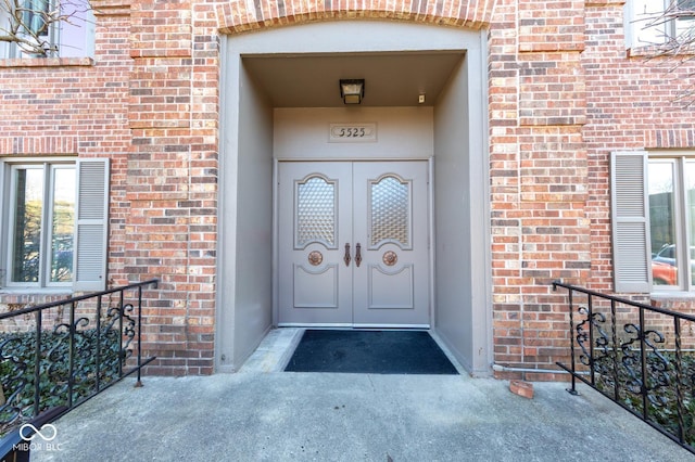 property entrance featuring french doors and brick siding