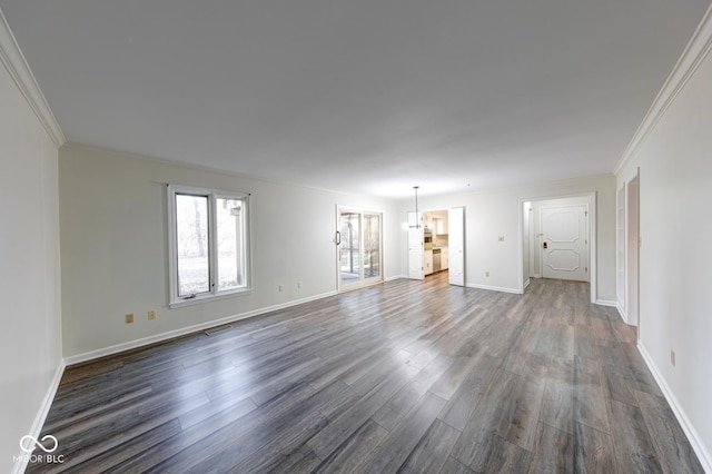 empty room with dark wood finished floors, visible vents, and crown molding