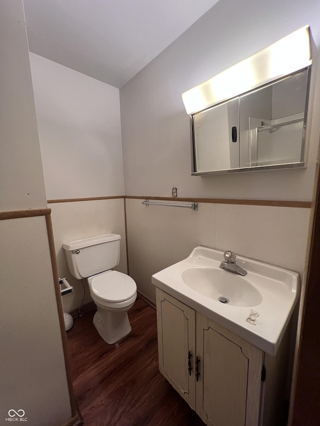 bathroom with toilet, wood finished floors, and vanity