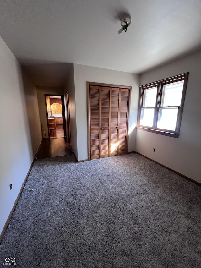 unfurnished bedroom featuring a closet, carpet flooring, and baseboards