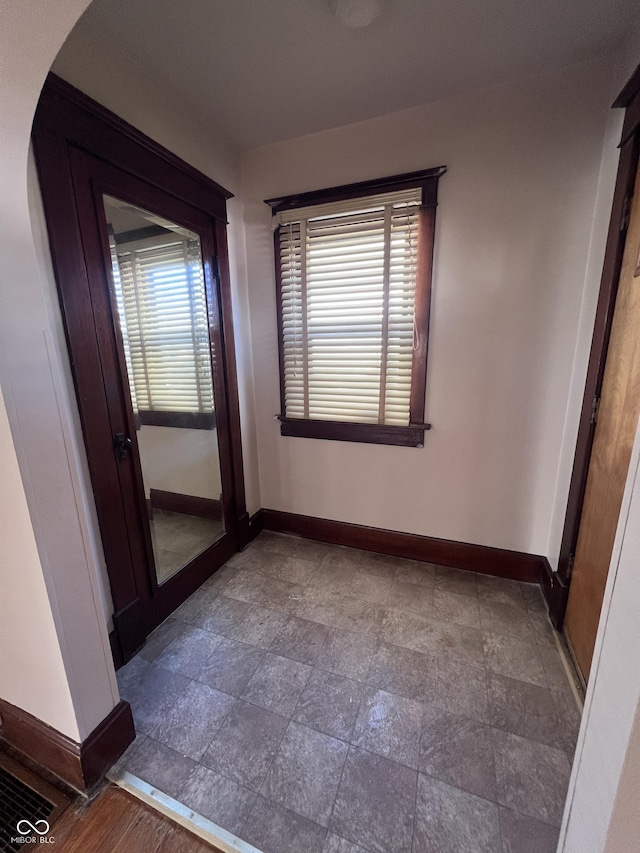 interior space with arched walkways, plenty of natural light, and baseboards