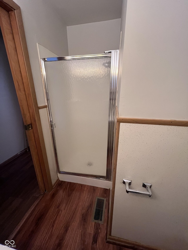 full bath featuring wood finished floors, visible vents, and a shower stall