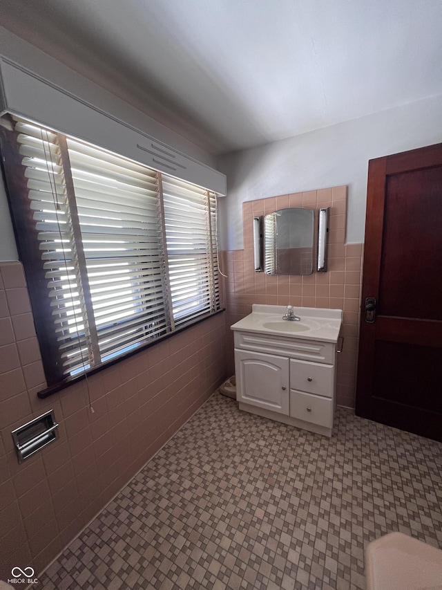 bathroom featuring vanity and tile walls