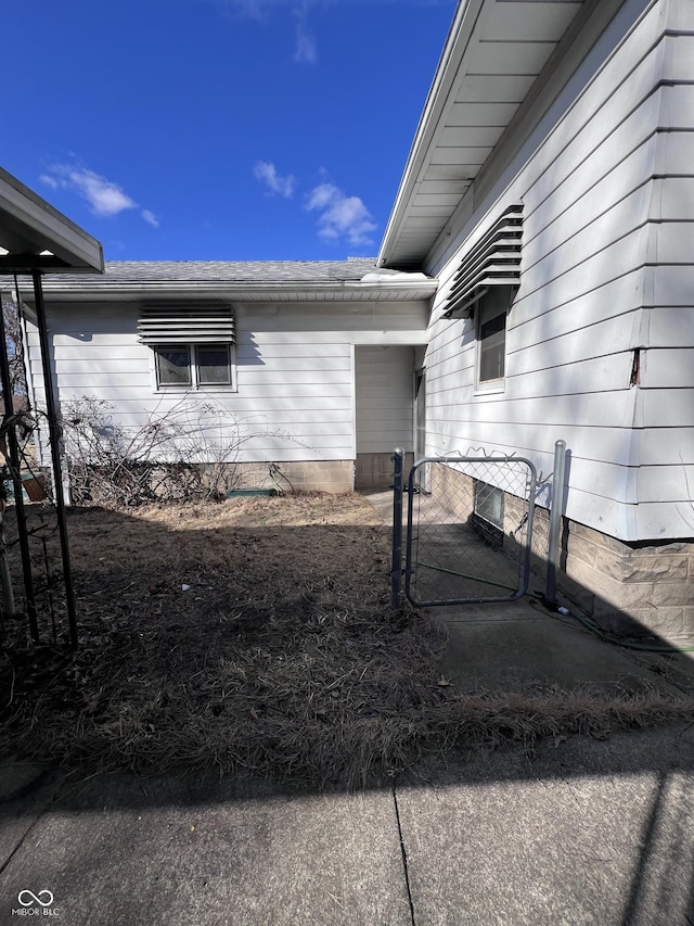 view of side of home featuring a gate and fence