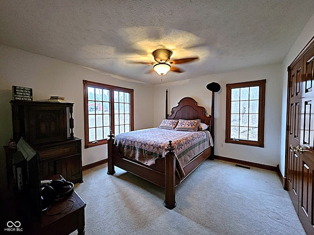 bedroom with visible vents, multiple windows, light colored carpet, and baseboards