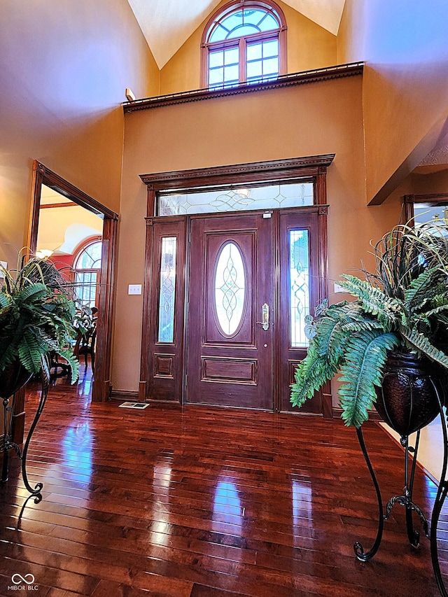 foyer entrance featuring hardwood / wood-style flooring and high vaulted ceiling