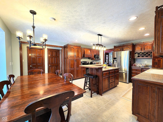 kitchen with a kitchen island, a breakfast bar area, light countertops, recessed lighting, and stainless steel appliances