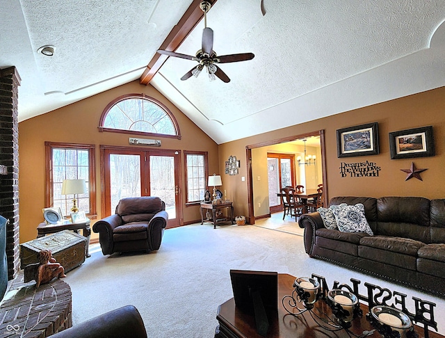 living area featuring lofted ceiling with beams, carpet floors, a textured ceiling, and ceiling fan with notable chandelier