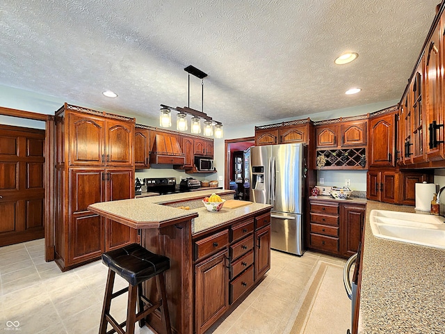 kitchen featuring stainless steel appliances, a sink, a kitchen island, a kitchen breakfast bar, and light countertops