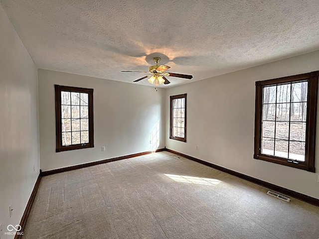 spare room featuring visible vents, baseboards, light colored carpet, and ceiling fan